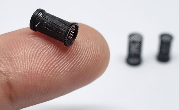 micro metal 3d printing shows a tiny printed metal piece on a fingertip