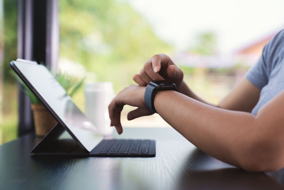 man using smart watch at work desk